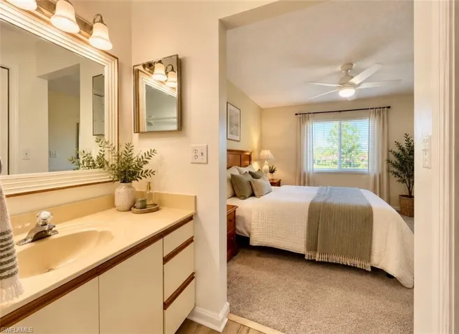 Vanity featuring a solid surface countertop with an integrated basin, **Virtually staged framed wall mirror, and dual-light sconce