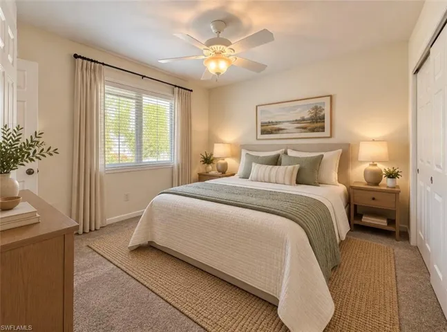 **Virtually staged Bedroom featuring neutral wall paint, carpeted flooring, a ceiling fan with integrated lighting, and dual-panel closet doors