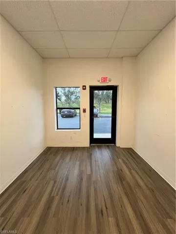 Unfurnished room with a drop ceiling and dark hardwood / wood-style floors