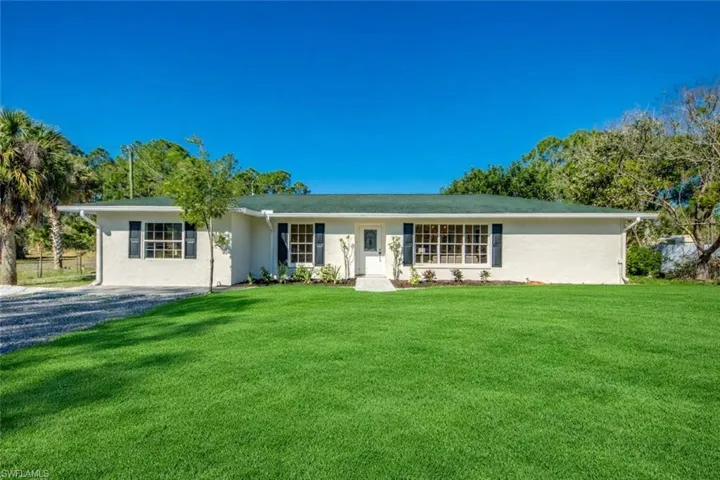 Single story home featuring a front yard and stucco siding
