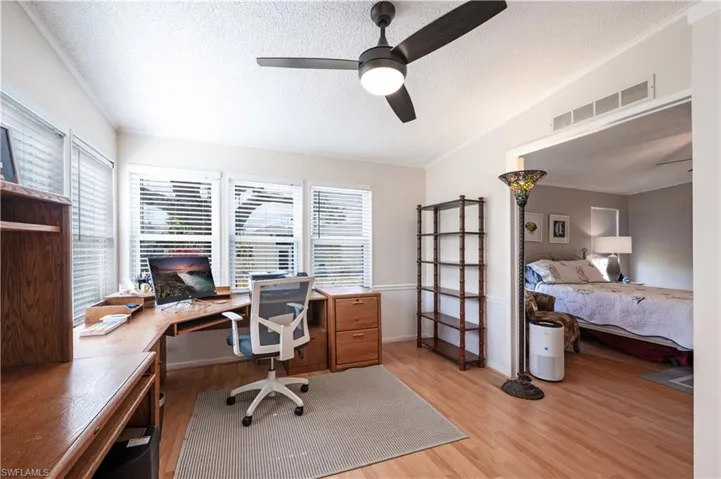 Office with a textured ceiling, a ceiling fan, and light wood-style flooring