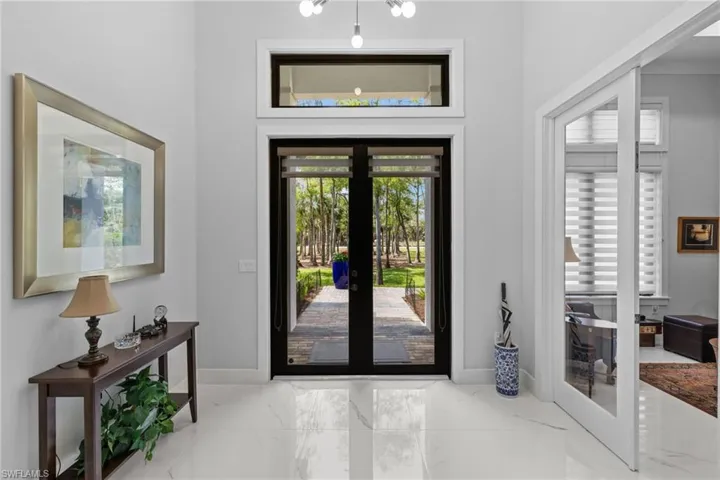 Entrance foyer with marble finish floor, baseboards, and french doors