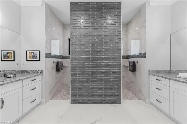 Bathroom with vanity and a marble finish shower
