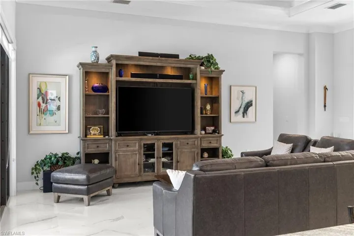Living room with marble finish floor, visible vents, and crown molding