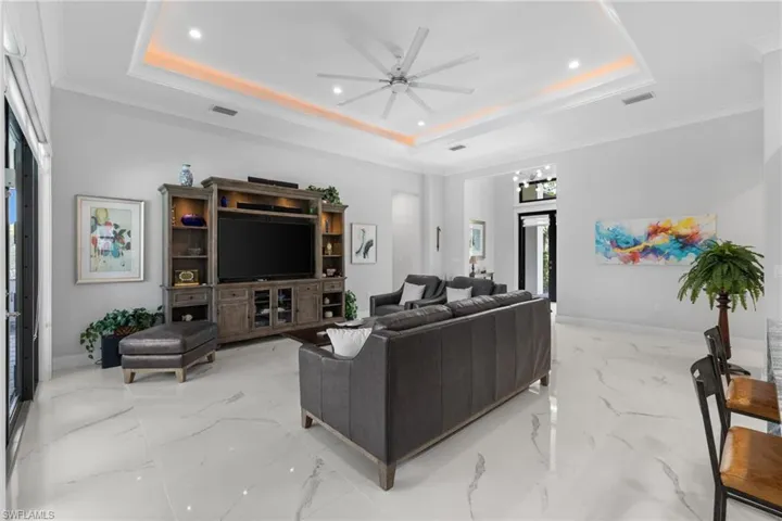 Living area featuring a tray ceiling and baseboards