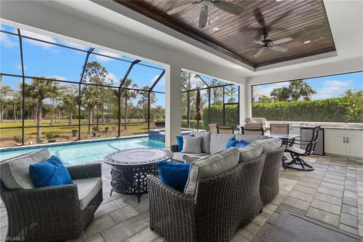 Sunroom with a pool, a tray ceiling, wooden ceiling, and ceiling fan