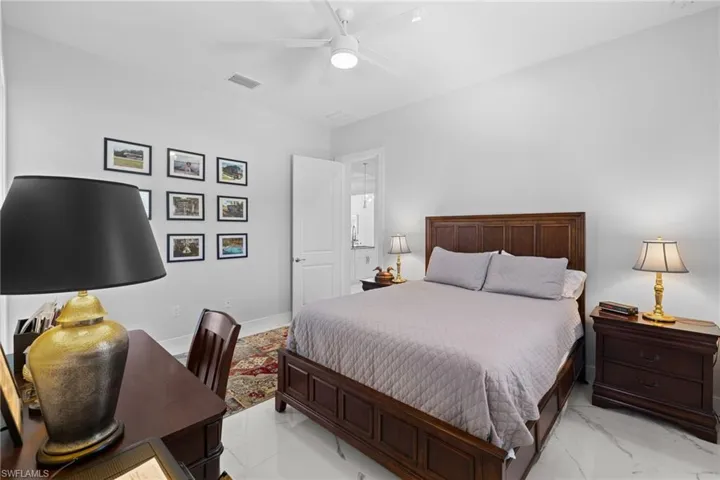 Bedroom featuring marble finish floor, a ceiling fan, visible vents, and baseboards