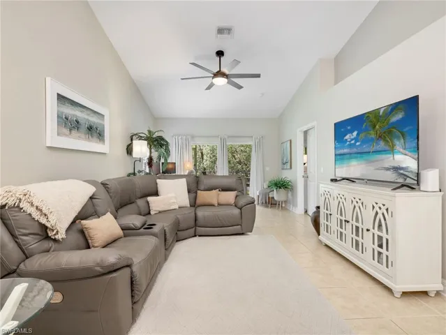 Living area with ceiling fan, vaulted ceiling, and light tile patterned floors