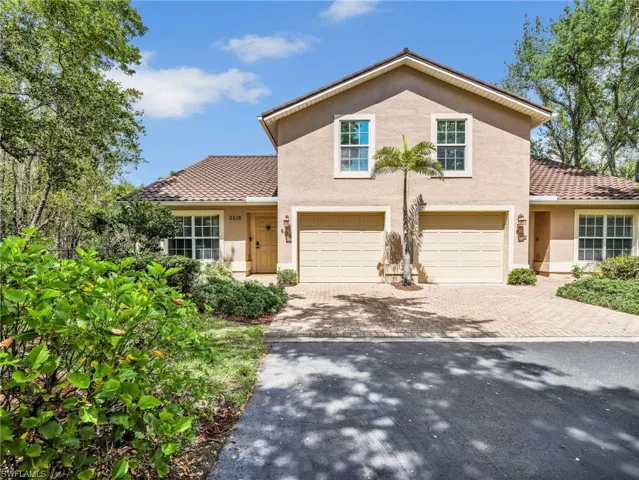 View of front of house with decorative driveway, stucco siding, and a garage