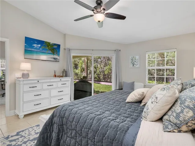 Bedroom with lofted ceiling, ceiling fan, access to exterior, and light tile patterned floors