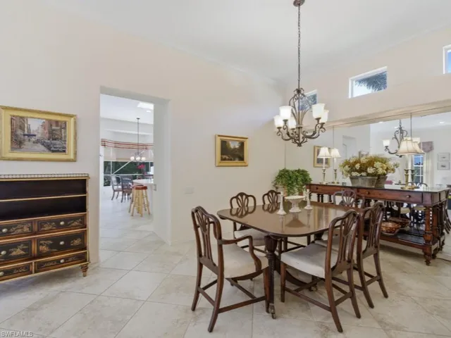 Dining room with hanging lights, crown molding, and light tile patterned flooring