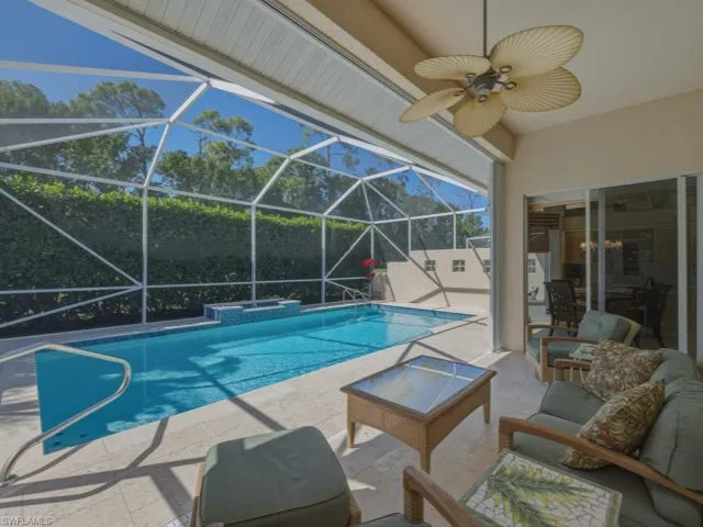 Swimming pool featuring a patio area, a sunroom, and glass enclosure