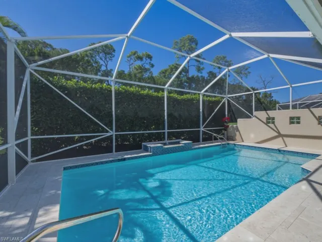 Swimming pool with a sunroom, glass enclosure, and a patio area