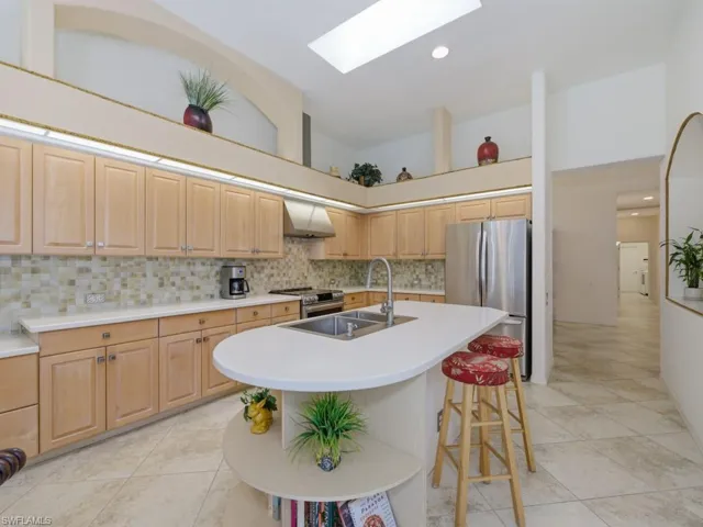 Kitchen featuring light wood finish cabinetry, a skylight, light countertops, stainless steel appliances, and recessed lighting