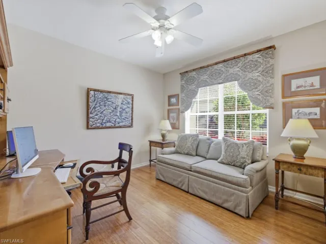 Home office with light wood-style floors and ceiling fan