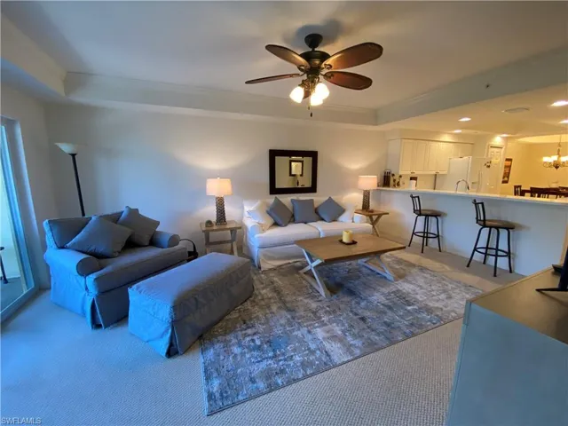 Living area featuring carpet floors, a tray ceiling, crown molding, ceiling fan, and recessed lighting