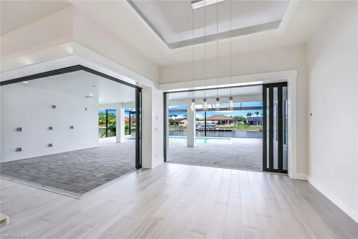 Empty room with a raised ceiling and light hardwood / wood-style floors