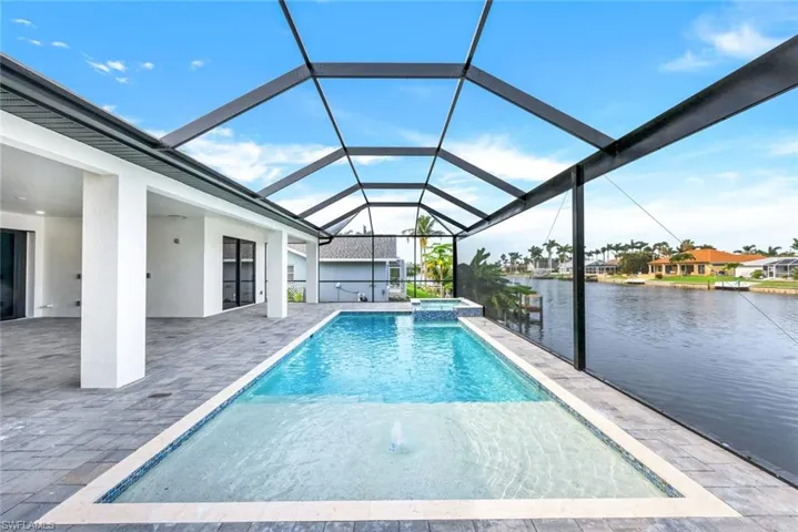 View of swimming pool featuring a water view, a lanai, and a patio area
