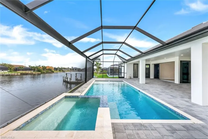 View of pool featuring a patio area, a lanai, and a water view
