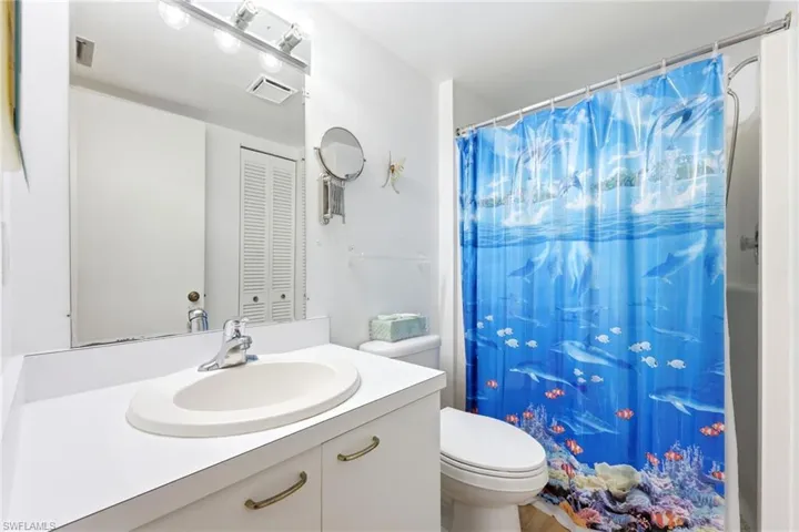 Bathroom featuring a white vanity with an integrated sink, chrome faucet, and under-sink storage