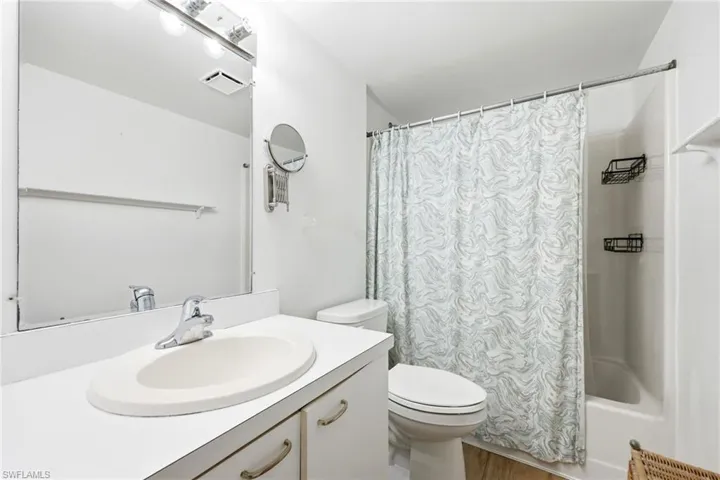 Bathroom featuring a white vanity with an integrated sink, a chrome faucet, and a large wall-mounted mirror