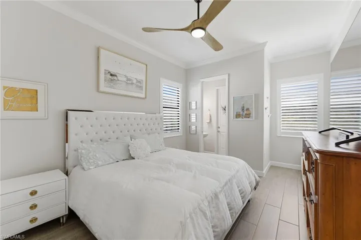 Bedroom featuring ornamental molding, ceiling fan, and light wood-style floors