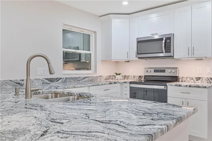 Kitchen with stainless steel appliances and white cabinetry
