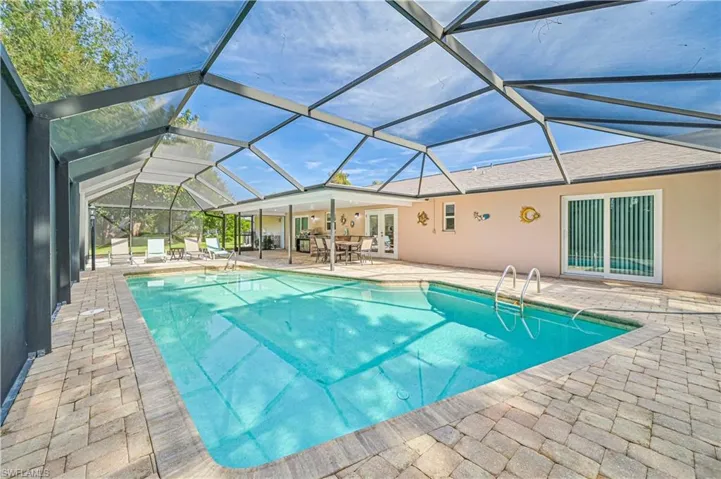 View of swimming pool featuring a lanai, a patio area, and french doors