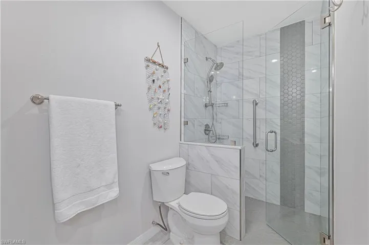 Bathroom featuring an enclosed shower and toilet