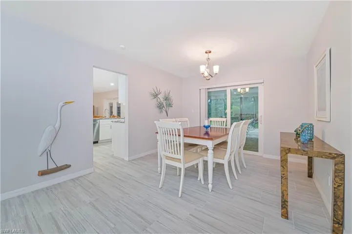 Dining room featuring a notable chandelier, light wood-type flooring, and sink
