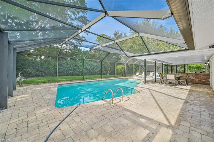 View of swimming pool with a patio and glass enclosure
