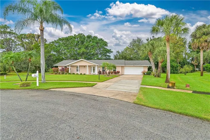 Ranch-style house with a front yard and a garage