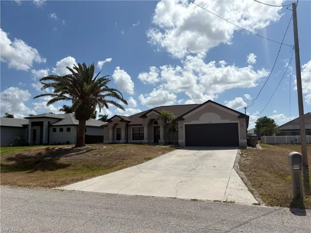 Single story home featuring concrete driveway, stucco siding, a front lawn, and an attached garage