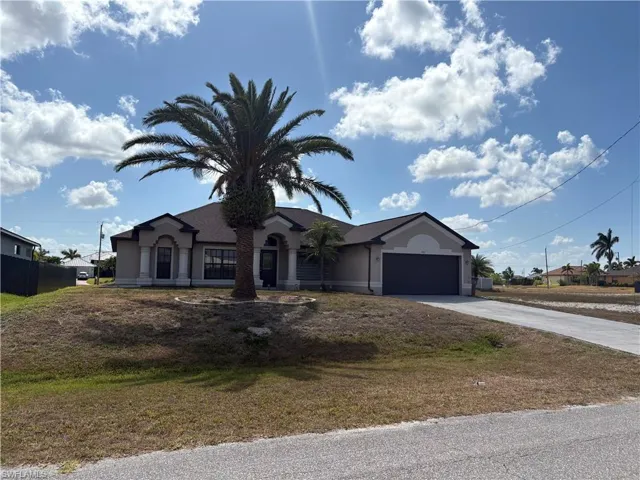 View of front of home with an attached garage, stucco siding, and driveway