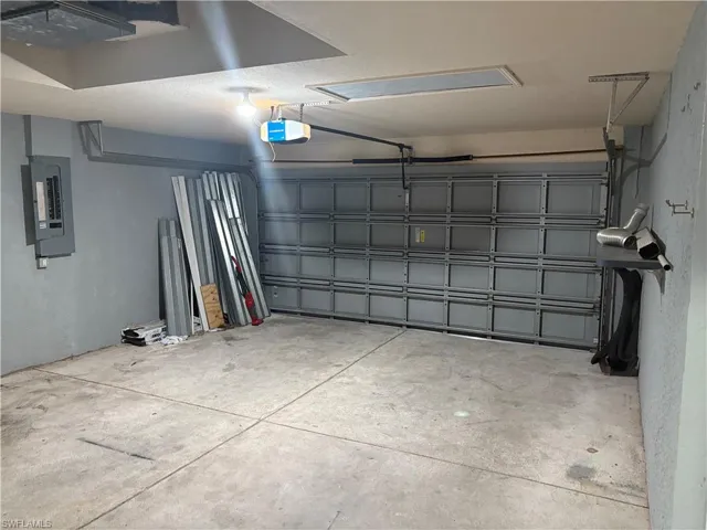 Garage featuring electric panel and a garage door opener