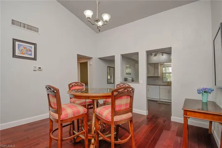 Dining space featuring a chandelier, visible vents, baseboards, and wood finished floors