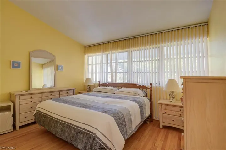 Bedroom featuring light wood-style flooring and lofted ceiling