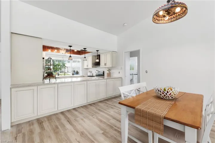 Dining area with light wood-style flooring and lofted ceiling