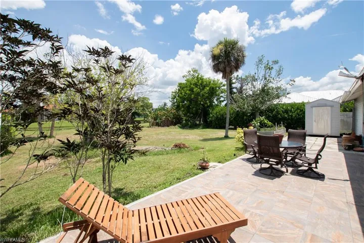 View of patio featuring outdoor dining area and a storage shed
