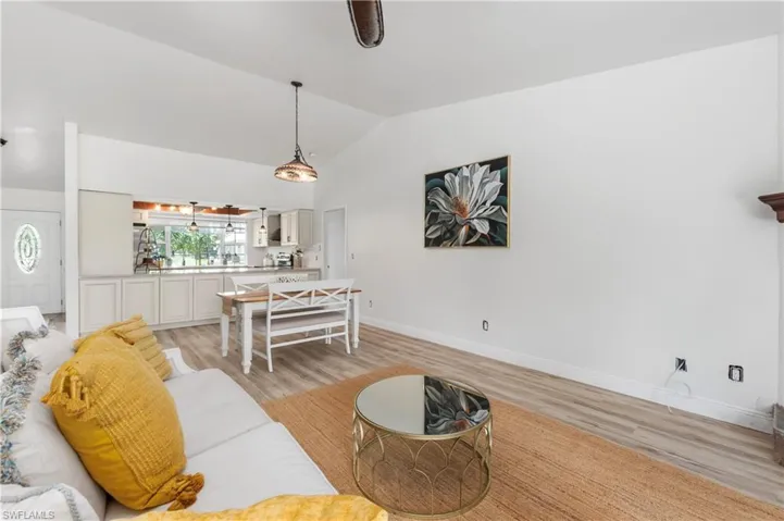 Living room featuring light wood-style floors and lofted ceiling