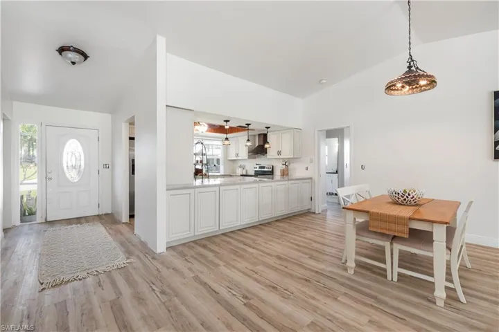 Foyer with light wood-type flooring, plenty of natural light, and high vaulted ceiling