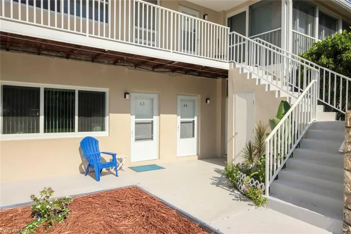 Ground-level entryways with exterior lighting, concrete patio, and white-painted stair railings