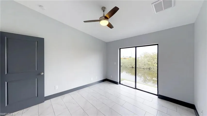 Light gray painted walls with dark gray trim, large glass sliding door, and a ceiling fan