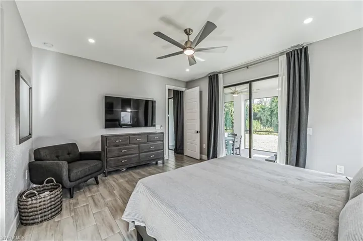 Light-toned wood-finish flooring extending throughout, recessed lighting, and a modern ceiling fan with integrated lighting