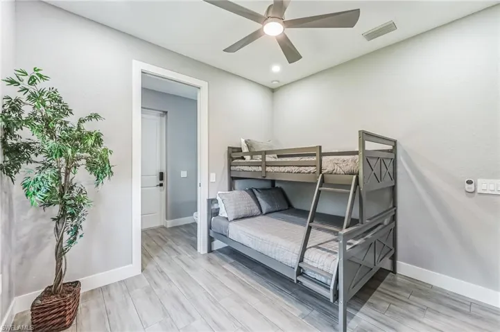 Room featuring wood-finish flooring, a contemporary ceiling fan with integrated lighting, and recessed ceiling lights