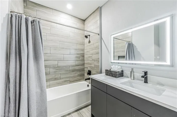 Contemporary bathroom featuring a tub and shower combination with wood-look tile surround