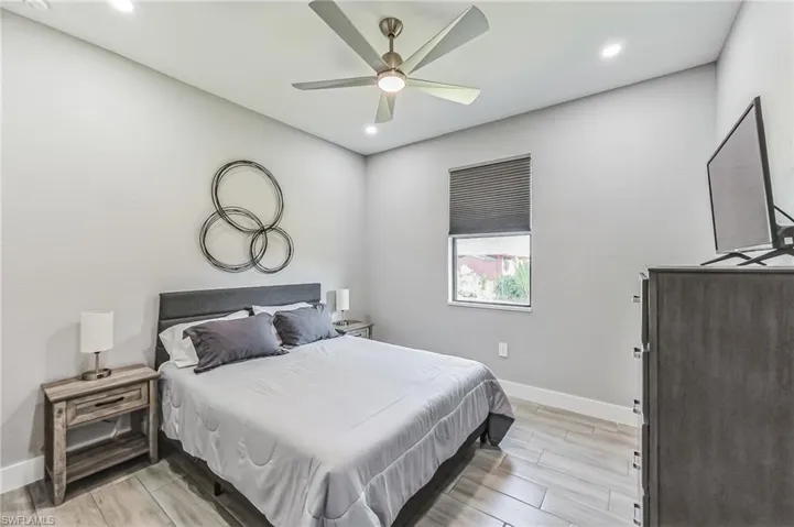 Bedroom featuring wood-finish tile flooring, recessed lighting, and a ceiling fan with integrated lighting