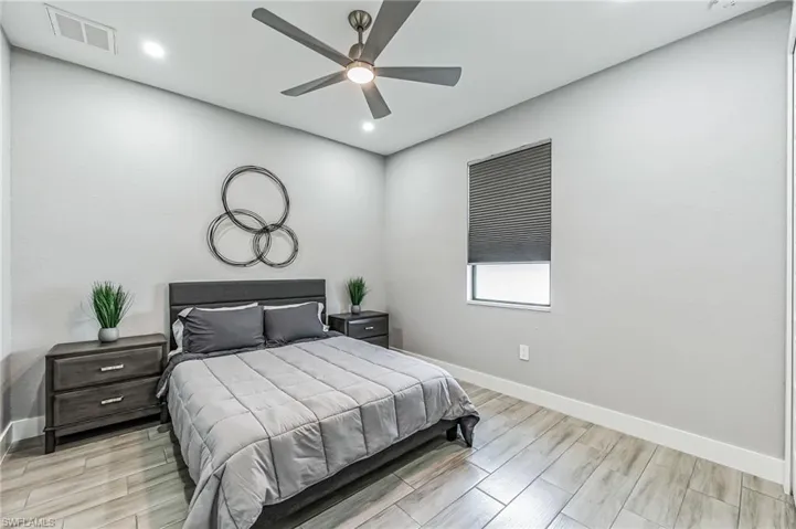 Spacious room featuring wood-finish flooring, recessed lighting, and a ceiling fan