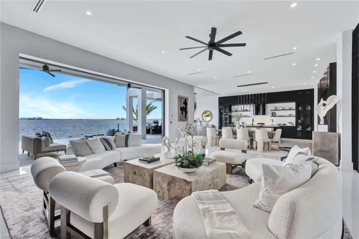 Living room with ceiling fan and a water view
