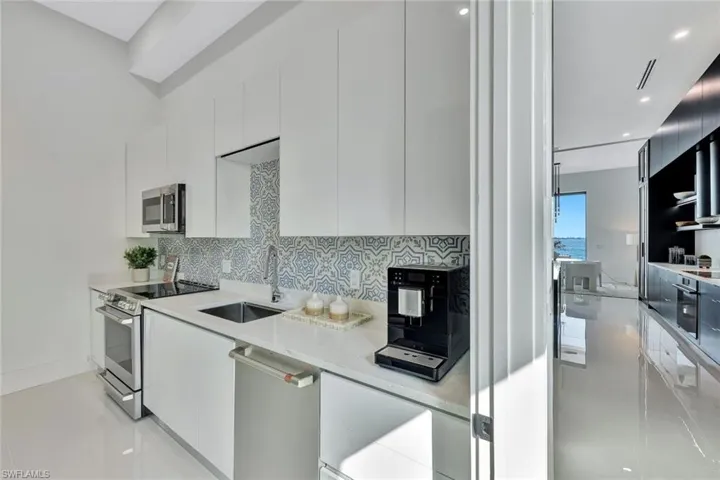 Kitchen featuring stainless steel appliances, white cabinetry, and sink